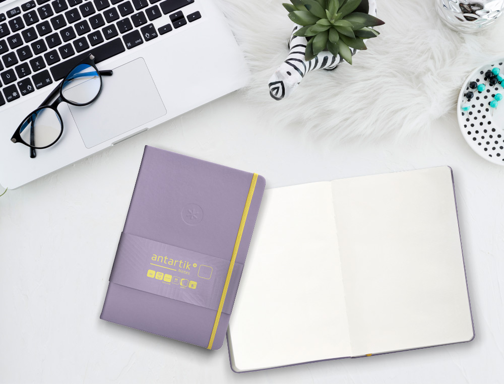 CUADERNO CON GOMILLA ANTARTIK NOTES TAPA DURA A5 HOJAS LISAS MORADO Y AMARILLO 100 HOJAS 80 GR FSC